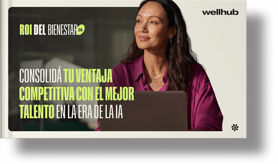 ROI del bienestar 2026: Consolidá tu ventaja competitiva con el mejor talento en la era de la IA. Una mujer con una camisa rosa mirando mientras trabaja con un laptop.