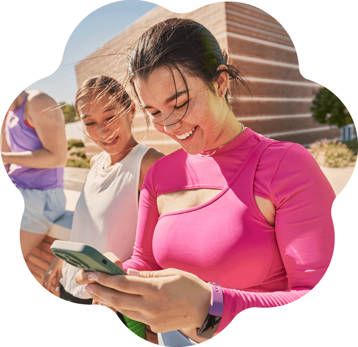 Woman in sportswear looking at her phone while smiling