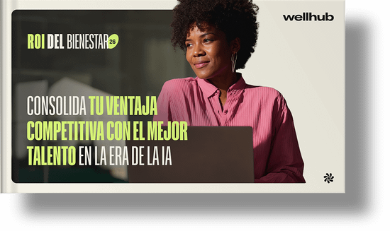 ROI del bienestar 2026: Consolida tu ventaja competitiva con el mejor talento en la era de la IA. Una mujer con una camiseta rosa que mira atentamente un portátil.