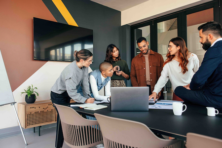 A group of coworkers looking over paperwork in a meeting room.