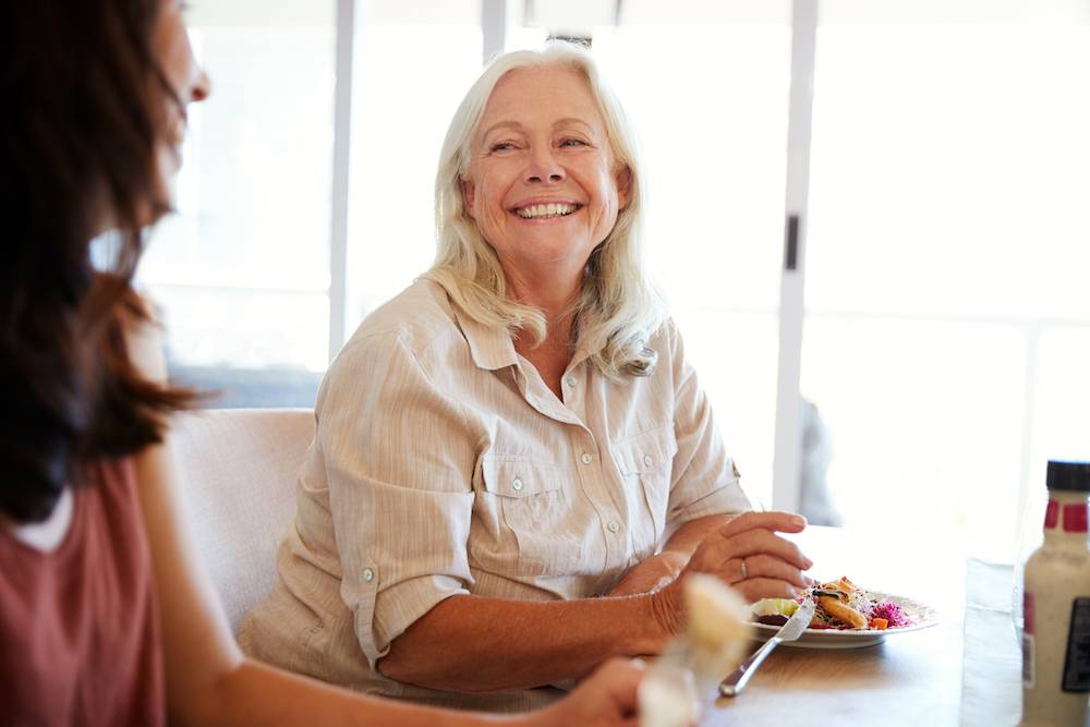 Senior white woman sitting at the family dinner table