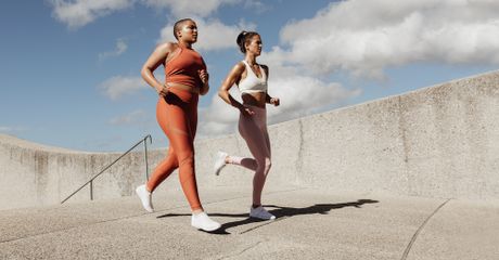 Two women wearing gym clothes, running.