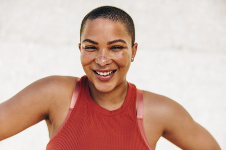 Woman wearing gym clothes smiling at the camera.