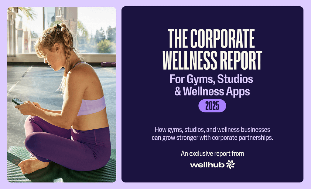 Woman sitting on a yoga mat using her phone, next to a Wellhub banner about the 2025 corporate wellness report.