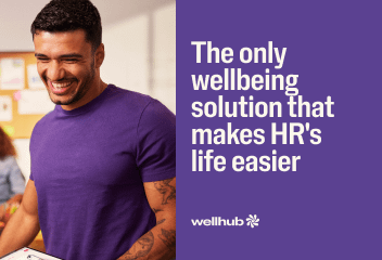 A smiling man in a purple shirt next to text: The only wellbeing solution that makes HR's life easier. Wellhub logo.