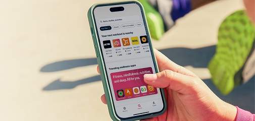 Una imagen en la que aparece un empleado/a haciendo check-in en una clase a través de la app de Wellhub. Se muestran los logotipos de algunas de las marcas de bienestar más populares disponibles en Wellhub.